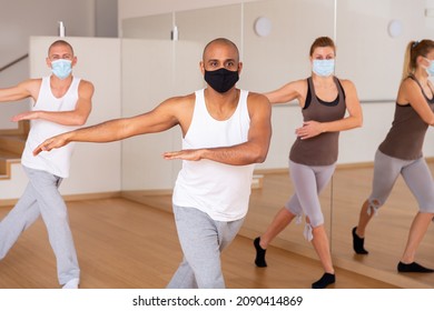 Portrait Of Male Dancer During Group Dance Workout In Fitness Center, All People Wearing Face Masks And Keeping Social Distance For Viral Protection