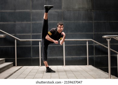 Portrait Of Male Dancer Performing In An Urban Environment. He Is Posing In An Modern Dance Move.