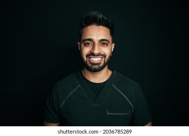 Portrait Of Male Dentist Standing In Clinic Smiling To Camera 