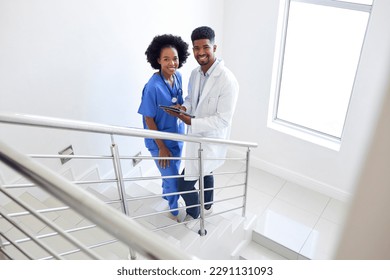 Portrait Of Male Doctor And Female Nurse With Digital Tablet On Stairs In Hospital - Powered by Shutterstock