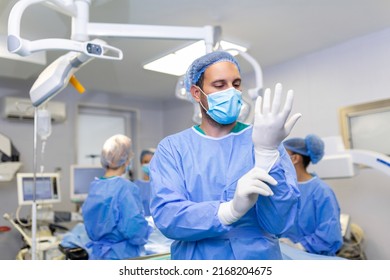 Portrait of male doctor surgeon putting on medical gloves standing in operation room. Surgeon at modern operating room - Powered by Shutterstock