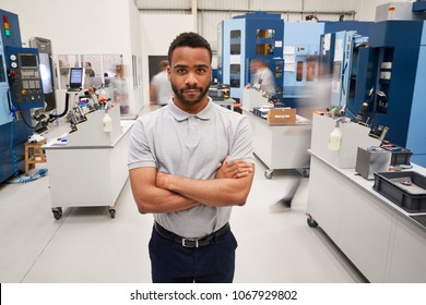 Portrait Of Male Engineer On Factory Floor Of Busy Workshop