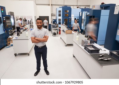 Portrait Of Male Engineer On Factory Floor Of Busy Workshop