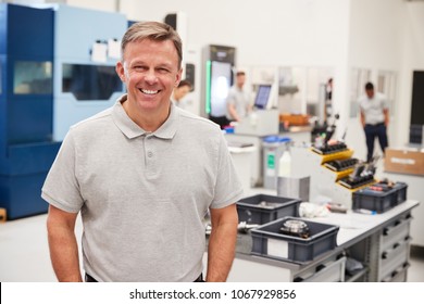 Portrait Of Male Engineer On Factory Floor Of Busy Workshop