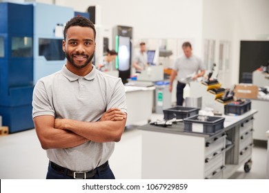 Portrait Of Male Engineer On Factory Floor Of Busy Workshop