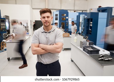 Portrait Of Male Engineer On Factory Floor Of Busy Workshop