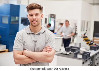 Portrait Of Male Engineer On Factory Floor Of Busy Workshop