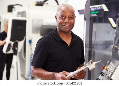 Portrait Of Male Engineer Operating CNC Machinery In Factory - Powered by Shutterstock