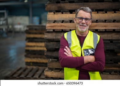 Portrait of male factory worker standing with arms crossed in drinks production factory - Shutterstock ID 650396473
