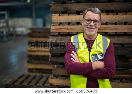 Portrait of male factory worker standing with arms crossed in drinks production factory