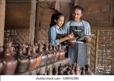 Portrait of male and female potter using digital tablet in pottery workshop. selling their product online - Powered by Shutterstock