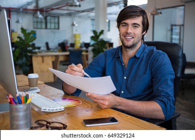 Portrait Of Male Graphic Designer At Desk In Office