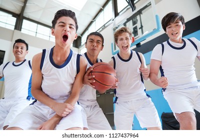 Portrait Of Male High School Basketball Team Celebrating On Court