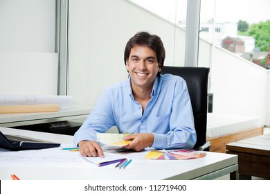 Portrait Of Male Interior Designer Working At Office With Color Swatches