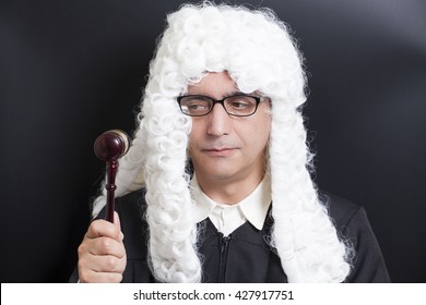 Portrait Of Male Lawyer with eyeglasses Holding Judge Gavel on black background