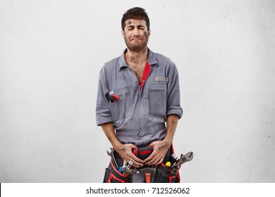 Portrait Of Male Mechanicer, Having Sorrorful Expression While Not Wanting To Work During Weekends, Going To Cry Because Of It. Untidy Manual Worker With Sad Look Isolated Over White Background