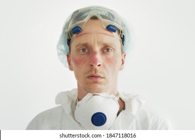 Portrait Of Male Nurse. Face Bruised And  Rubbed Raw By Face Mask On White Background