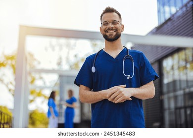 Portrait of male nurse at hospital. Portrait of a smiling doctor. Doctor with stethoscope standing, crossed arms, isolated on bright background. Portrait of a friendly doctor smiling at the camera. - Powered by Shutterstock