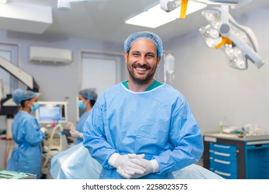 Portrait of male nurse surgeon OR staff member dressed in surgical scrubs gown mask and hair net in hospital operating room theater making eye contact smiling pleased happy looking at camera - Powered by Shutterstock