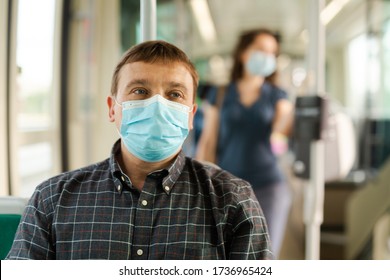 Portrait of male passenger in disposable face mask and latex gloves traveling by city streetcar. Concept of prevention and social distancing in coronavirus pandemic
