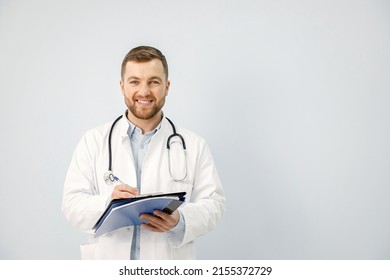 Portrait of a male physician holding a document isolated on white background - Shutterstock ID 2155372729