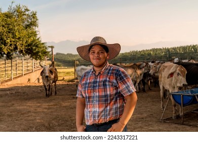 Portrait of a male rancher looking at camera with cattle in the background. - Powered by Shutterstock