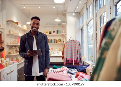 Portrait Of Male Small Business Owner Checks Stock In Shop Using Digital Tablet