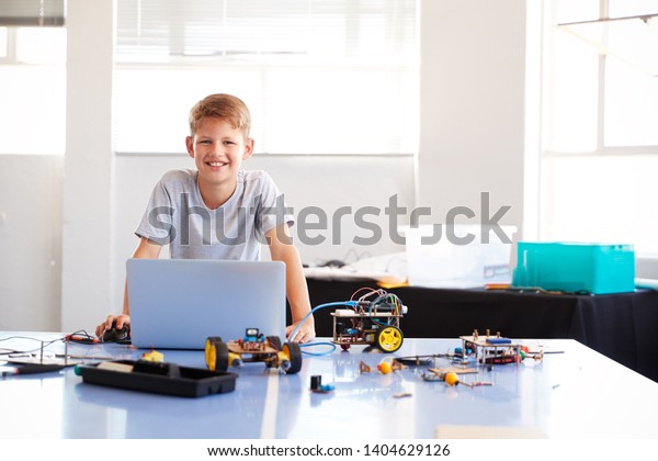 Portrait Of Male Student Building\
And Programing Robot Vehicle In School Computer Coding\
Class
