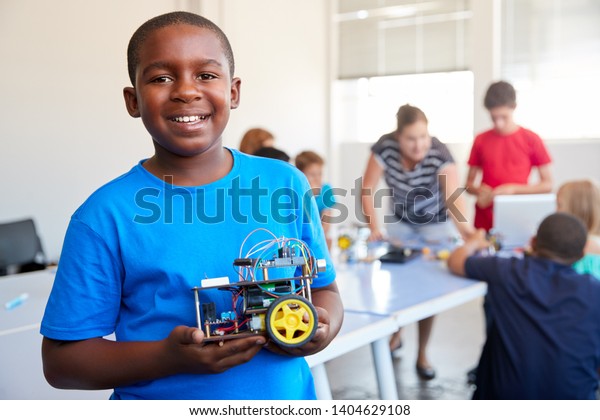 Portrait Of Male Student Building Robot\
Vehicle In After School Computer Coding\
Class