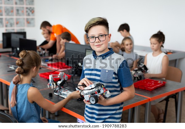 Portrait Of Male Student Building Robot\
Vehicle In After School Computer Coding\
Class