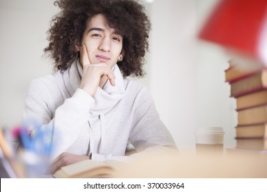 Portrait of male student studying at table - Shutterstock ID 370033964