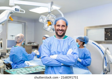 Portrait of male surgeon in operation theater looking at camera. Doctor in scrubs and medical mask in modern hospital operating room. - Powered by Shutterstock