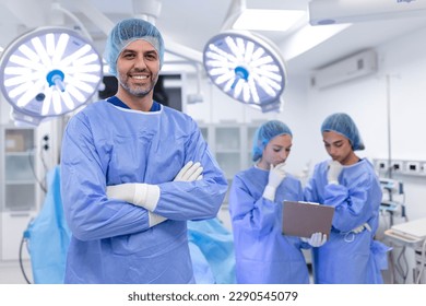 Portrait of male surgeon standing with arms crossed in operation theater at hospital. Team surgeons are performing an operation, middle aged doctor is looking at camera, in a modern operating room - Powered by Shutterstock