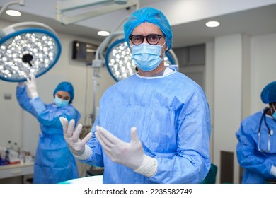 Portrait of male surgeon wearing surgical mask in operation theater at hospital. Healthcare workers in the Coronavirus Covid19 pandemic - Powered by Shutterstock