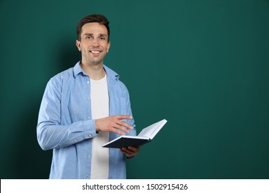 Portrait Of Male Teacher With Book On Color Background. Space For Text