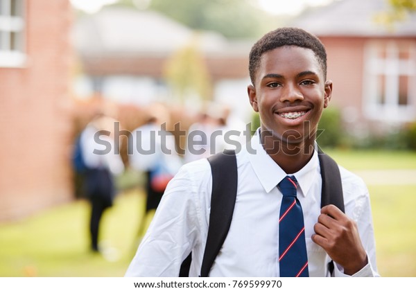 Portrait Of Male Teenage Student In Uniform\
Outside Buildings