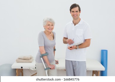 Portrait of a male therapist and disabled senior patient with reports in the gym at hospital - Powered by Shutterstock