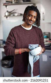 Portrait Of Male University Or College Student Drying Up Bowl L In Campus Kitchen