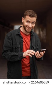 Portrait Of A Man 20-30 Years Old Looking At The Phone On The Street, Using The Phone