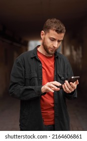 Portrait Of A Man 20-30 Years Old Looking At The Phone On The Street, Using The Phone