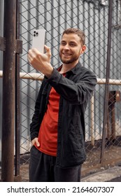 
Portrait Of A Man 20-30 Years Old Looking At The Phone On The Street, Video Chat, Selfie