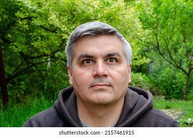 Portrait Of A Man 40-50 Years Old, Gray-haired, Swarthy. Looking On Top Of Camera. Big Eyebrows.