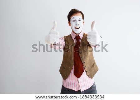 Portrait of man, actor, pantomime, man making class gesture, thumb up. Emotions, facial expressions, feelings, body language, signs. Image on white studio background