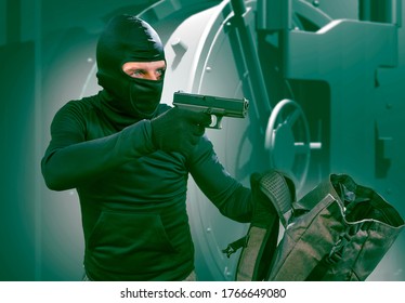 Portrait Of Man In Balaclava Mask Holding Gun In Front Of Security Metal Vault Door In Bank Or Casino Heist Concept In Heist Hollywood Movie Style