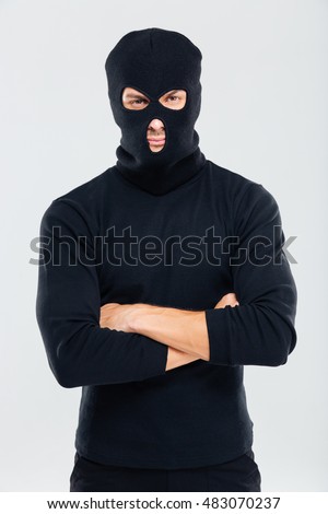 Portrait of man in balaclava standing with arms crossed