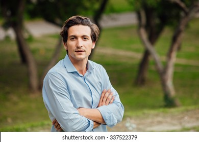 Portrait Of A Man In Blue Shirt Standing Outside In Park