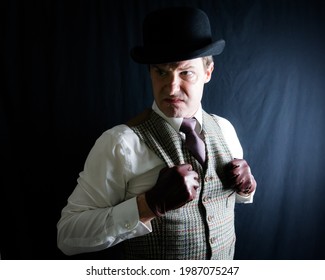 Portrait of Man in Bowler Hat and Tweed Vest With a Mean Expression on Black Background. Old-Fashioned Ruffian or Rogue. Uncouth Cad and Notorious Criminal - Shutterstock ID 1987075247