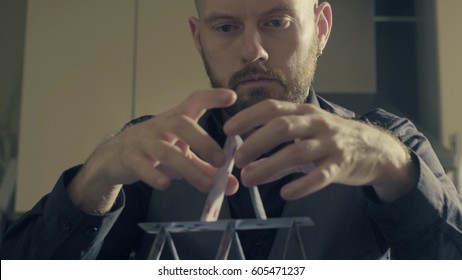 Portrait Of A Man Building A House Of A Playing Cards.