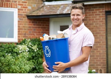 Portrait Of Man Carrying Recycling Bin