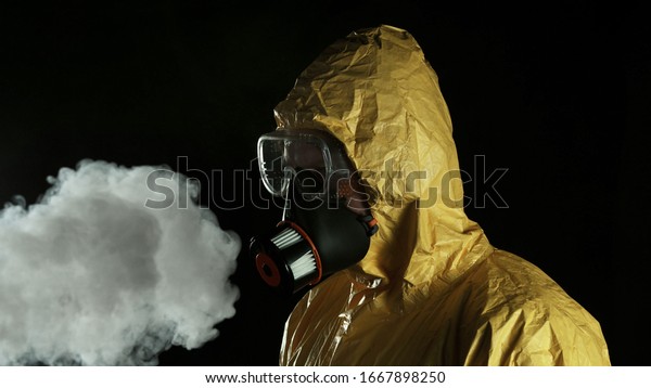 Portrait of a man in chemical suit with\
respirator and goggles. Concept of protection against viruses,\
biological attack or chemical\
pollution.